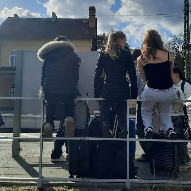 Jugendliche mit Koffern am Bahnhof